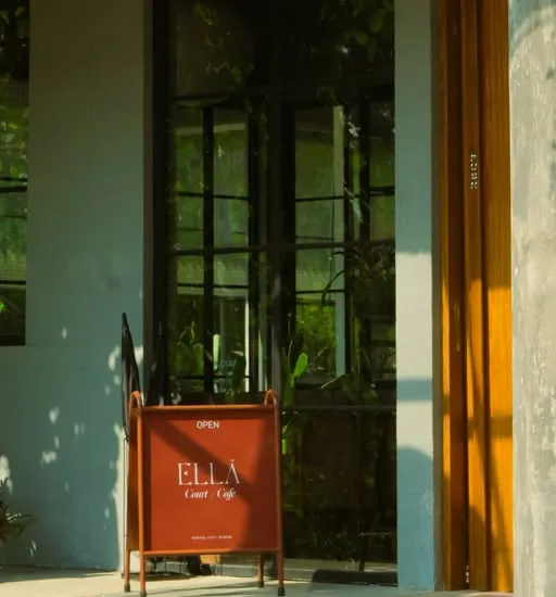 The Ella Café sign at the entrance in afternoon sun